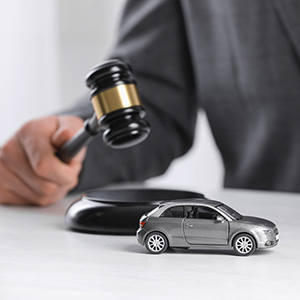 Attorney with a gavel and toy car; preparing for a first legal consultation for accidents in Florida.